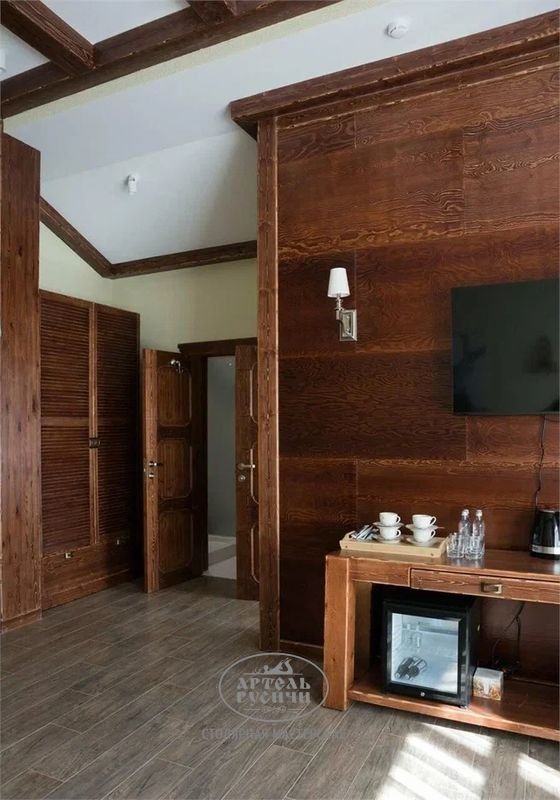Мебель для гостиницы из дерева: на фото платяной шкаф из массива сосны, столик консоль, стеновые панели и дверь из массива под старину