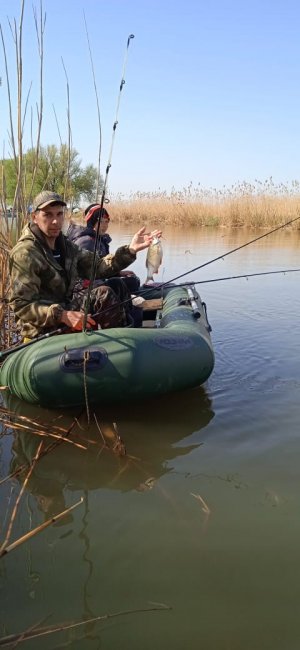 Геннадий Могиляс с сыном рыбачат на лодке