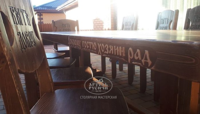 Деревянная обеденная группа под старину с резными надписями на спинках стульях и на торце стола