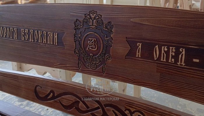 Фамильный герб и резная надпись на спинке скамейки из коллекции "Драккар"