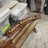 Изогнутая деревянная вывеска с резной надписью